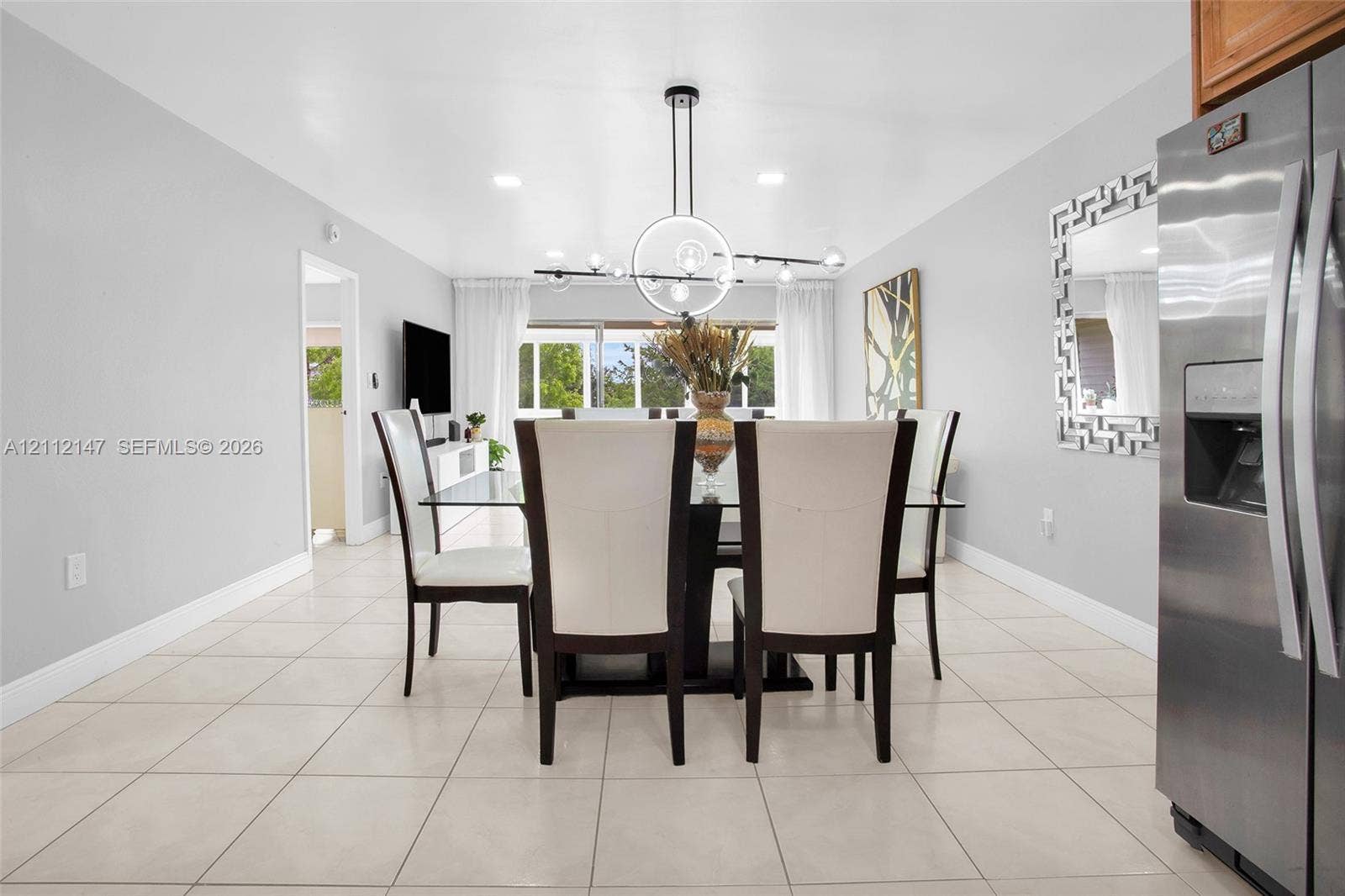 8331 Sands Point Boulevard, #C308, Tamarac, FL 33321 Dining area featuring large-format tile flooring, a geometric multi-light pendant fixture, recessed ceiling lighting, and a stainless steel side-by-side refrigerator