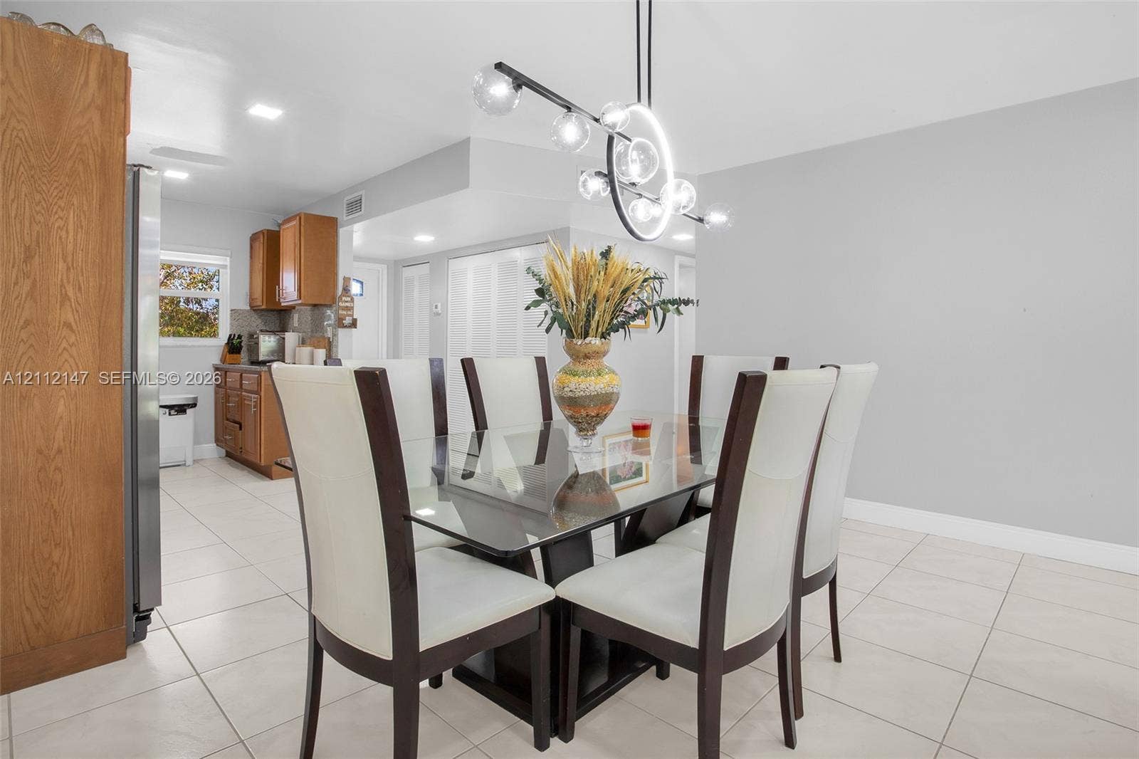 8331 Sands Point Boulevard, #C308, Tamarac, FL 33321 Dining area featuring large-format ceramic tile flooring, a modern multi-globe chandelier, and recessed lighting