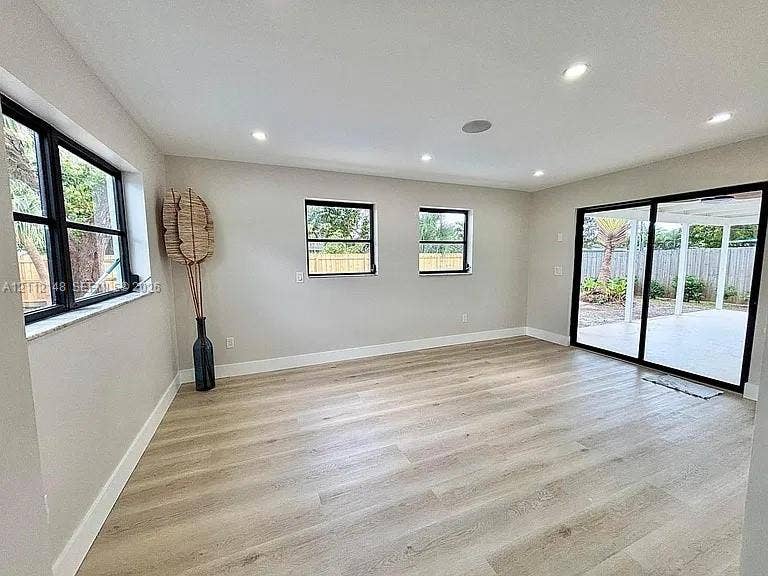 1753 N 16th Court N, Lake Worth, Lake Worth, FL 33460 Interior space featuring wood-finish flooring, recessed lighting, black-framed windows, and sliding glass doors with direct patio access