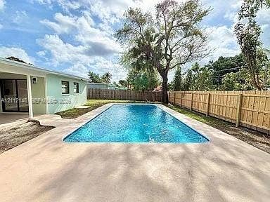 1753 N 16th Court N, Lake Worth, Lake Worth, FL 33460 Rectangular in-ground swimming pool with concrete decking, enclosed by wood privacy fencing and mature trees