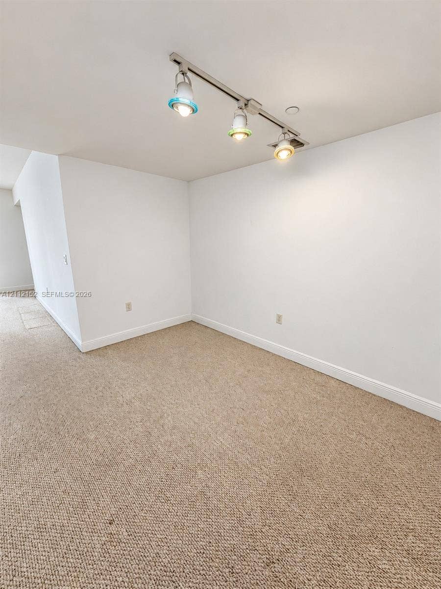 Neutral wall-to-wall carpeting and adjustable three-light track fixture