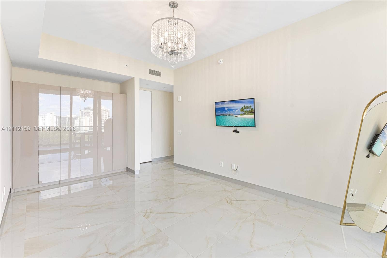 18975 Collins Avenue, #802, Sunny Isles Beach, Sunny Isles Beach, FL 33160 Polished stone flooring, floor-to-ceiling glass wall panels, and an ornate crystal chandelier