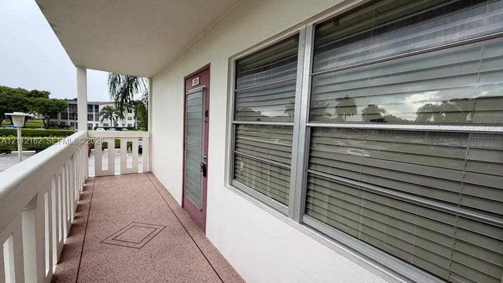 309 Fanshaw H, #309, Boca Raton, FL 33434 Covered exterior corridor with concrete flooring, white protective railing, and exterior entrance door