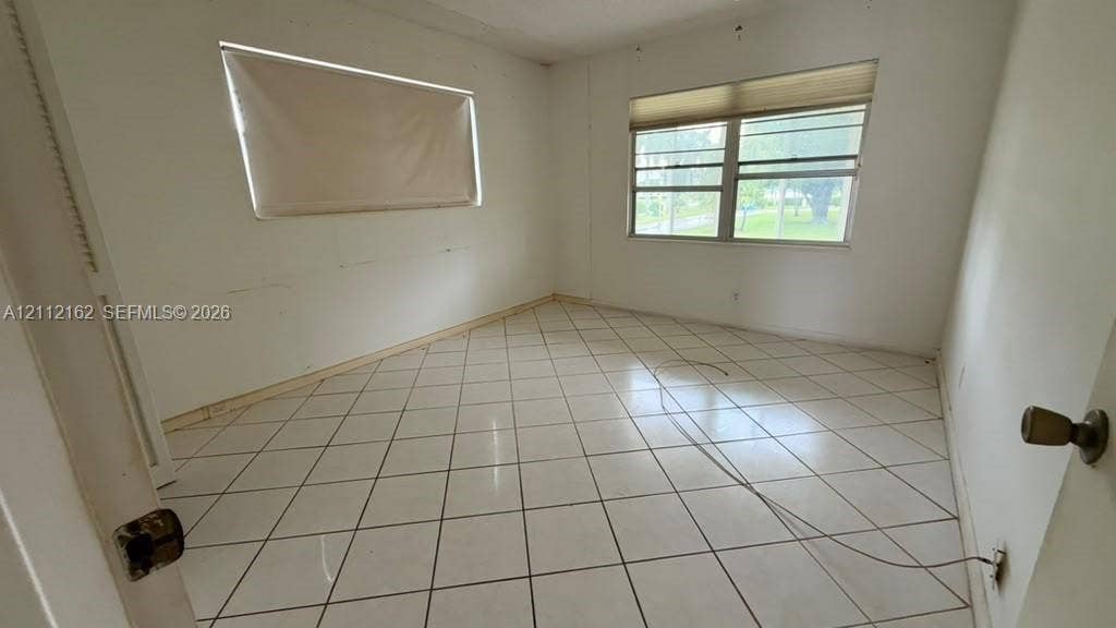 309 Fanshaw H, #309, Boca Raton, FL 33434 Bright room featuring neutral ceramic tile flooring and two windows with installed window treatments