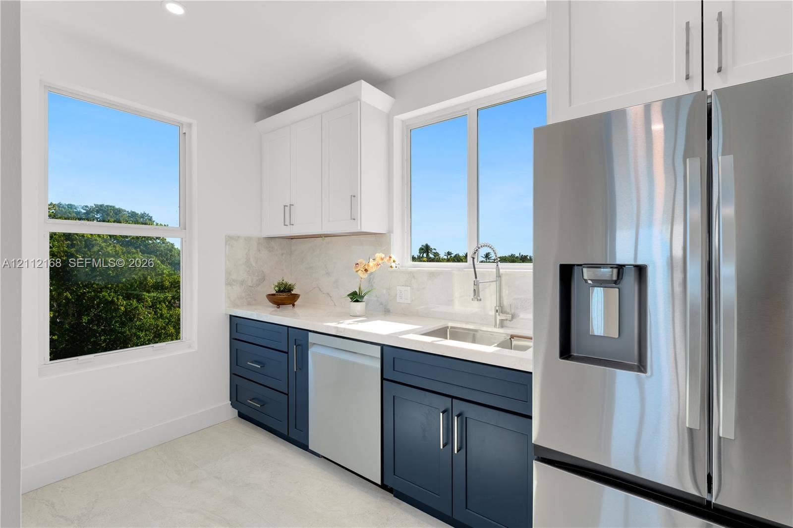1041 E Buttonwood Drive, Sugarloaf Key, FL 33042 Kitchen featuring two-tone cabinetry, stone-finish countertops, stainless steel appliances, and large windows