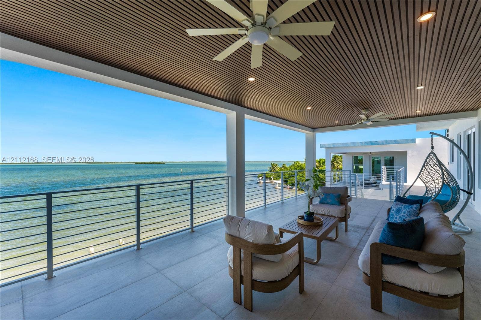 1041 E Buttonwood Drive, Sugarloaf Key, FL 33042 Covered terrace featuring a slatted wood ceiling, recessed lighting, ceiling fans, large-format tile flooring, and a stainless steel cable railing system