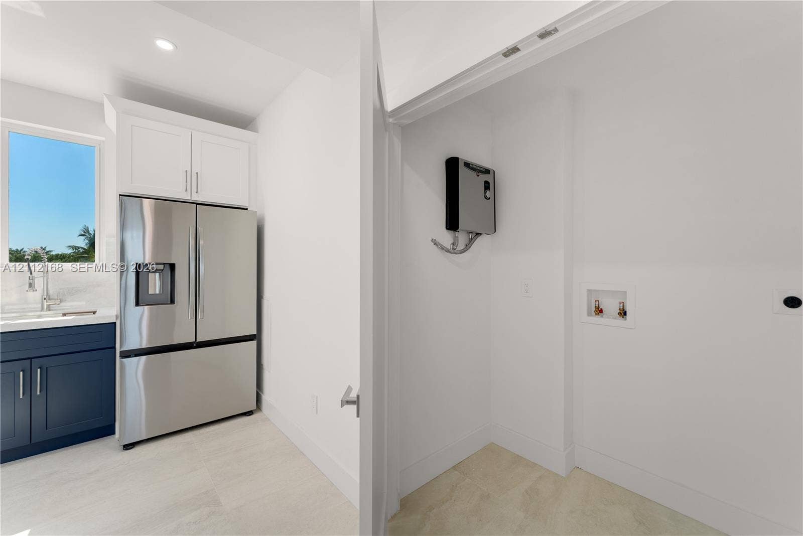 1041 E Buttonwood Drive, Sugarloaf Key, FL 33042 Stainless steel french-door refrigerator, dark navy cabinetry, white upper cabinetry, recessed lighting, and designated utility area with plumbing hookups