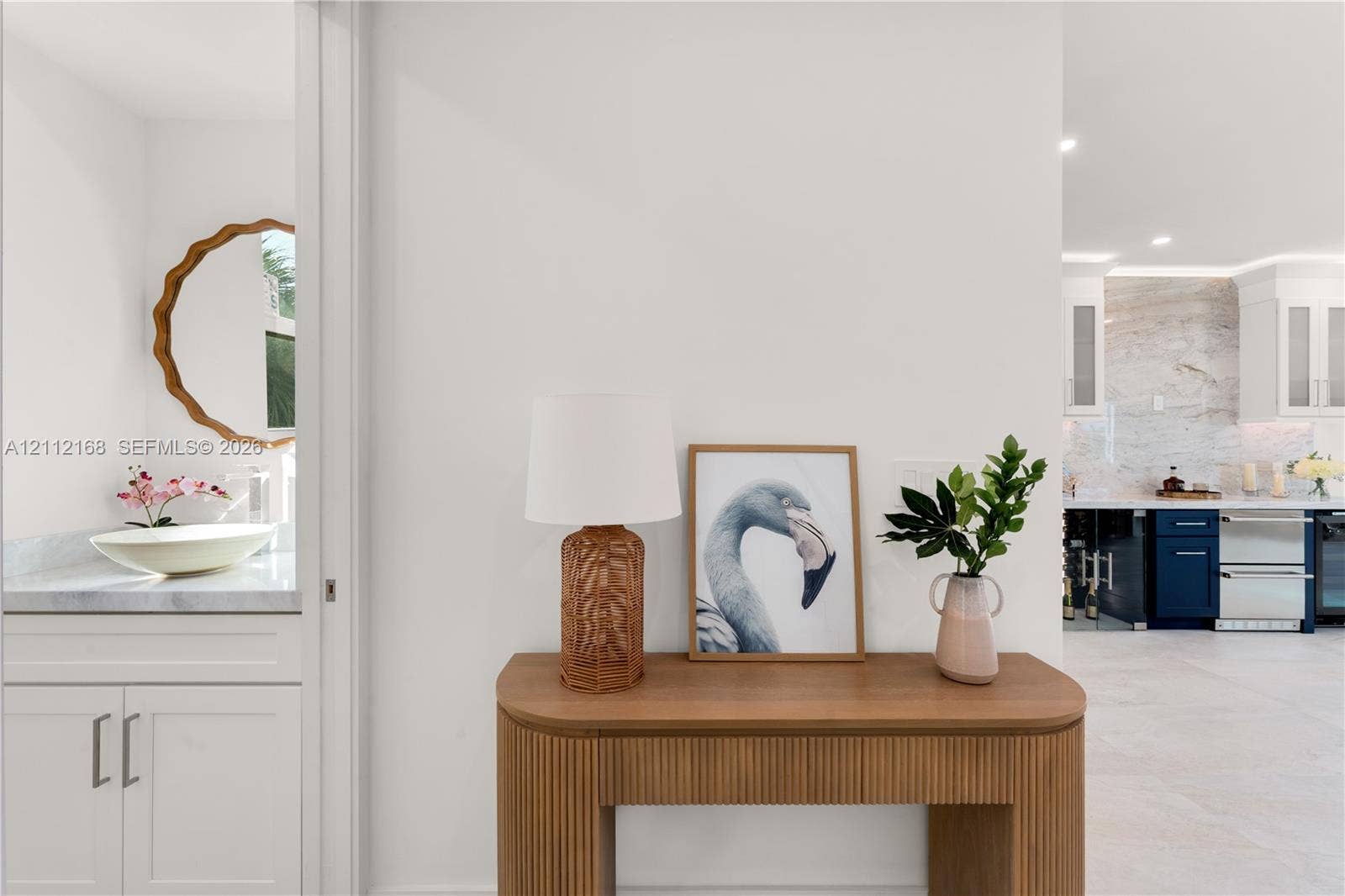 1041 E Buttonwood Drive, Sugarloaf Key, FL 33042 Custom vanity featuring a stone countertop, vessel sink, and scalloped-edge circular mirror, accented by cabinetry with flat-panel doors and recessed lighting