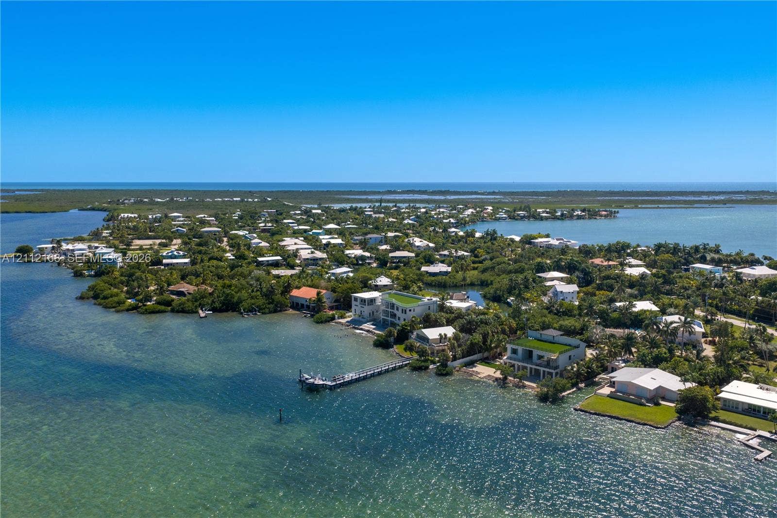 1041 E Buttonwood Drive, Sugarloaf Key, FL 33042 Aerial perspective of waterfront property featuring an extended deep-water dock, direct shoreline access, and expansive coastal surroundings