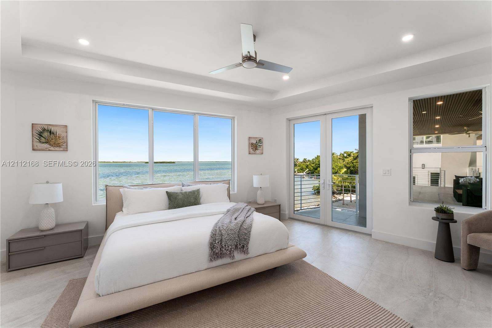 1041 E Buttonwood Drive, Sugarloaf Key, FL 33042 Tray ceiling with recessed lighting, floor-to-ceiling windows, modern ceiling fan, and glass-paneled double doors opening to a balcony