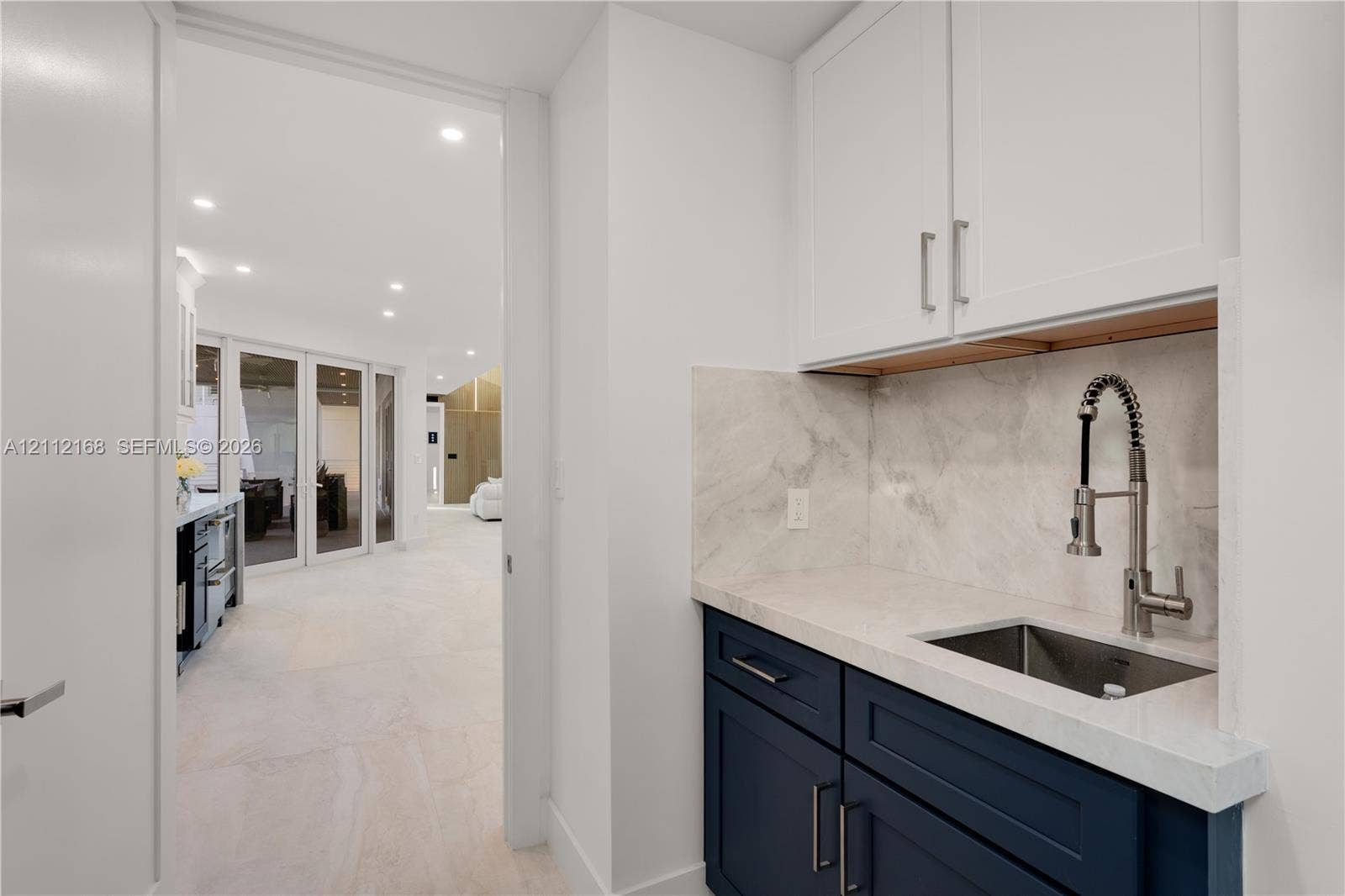 1041 E Buttonwood Drive, Sugarloaf Key, FL 33042 Wet bar featuring dark blue cabinetry, stone-finish countertop, coordinating backsplash, undermount stainless steel sink, and a gooseneck faucet