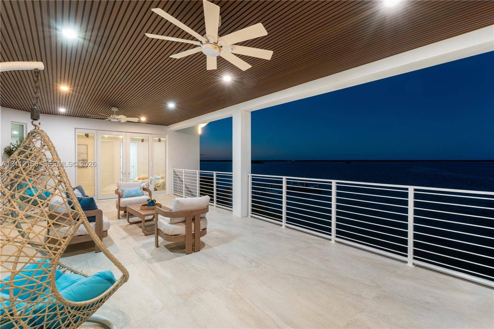 1041 E Buttonwood Drive, Sugarloaf Key, FL 33042 Covered terrace featuring a slatted wood-finish ceiling, large-format tile flooring, white metal horizontal railing, and recessed lighting