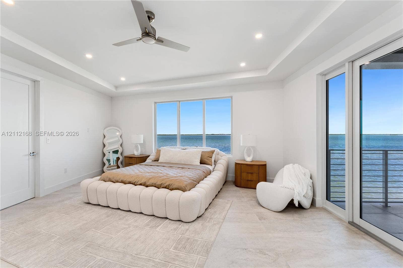 1041 E Buttonwood Drive, Sugarloaf Key, FL 33042 Tray ceiling with recessed lighting, large-format tile flooring, ceiling fan, and floor-to-ceiling glass sliding doors opening to an exterior balcony
