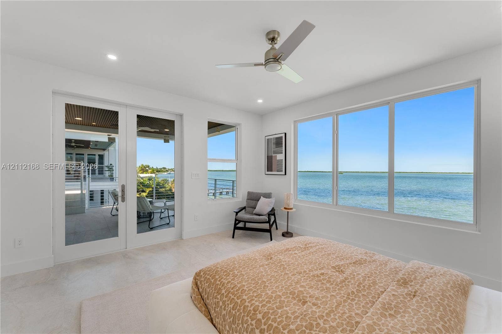 1041 E Buttonwood Drive, Sugarloaf Key, FL 33042 Floor-to-ceiling windows, double glass doors with access to the exterior, recessed lighting, brushed nickel ceiling fan, and light-toned tile flooring