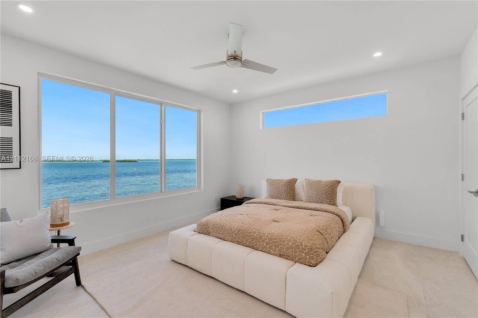 1041 E Buttonwood Drive, Sugarloaf Key, FL 33042 Large windows featuring water scenery, additional clerestory window, recessed lighting, and a modern ceiling fan