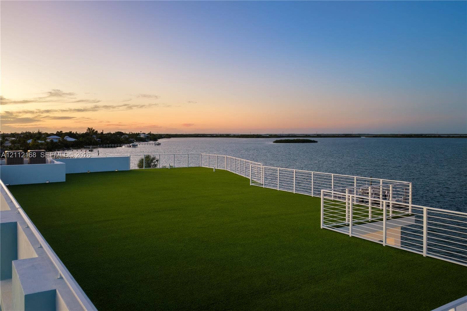 1041 E Buttonwood Drive, Sugarloaf Key, FL 33042 Expansive rooftop terrace featuring synthetic turf flooring and horizontal cable railing