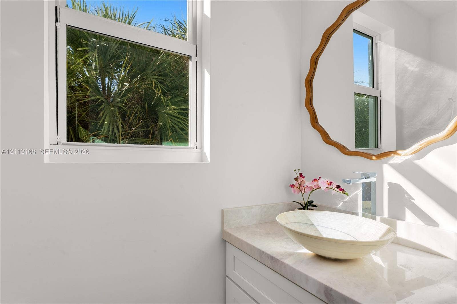 1041 E Buttonwood Drive, Sugarloaf Key, FL 33042 Vanity featuring a stone-surface countertop, an oval vessel sink, a chrome single-handle faucet, and white shaker-style cabinetry, complemented by a single-hung window