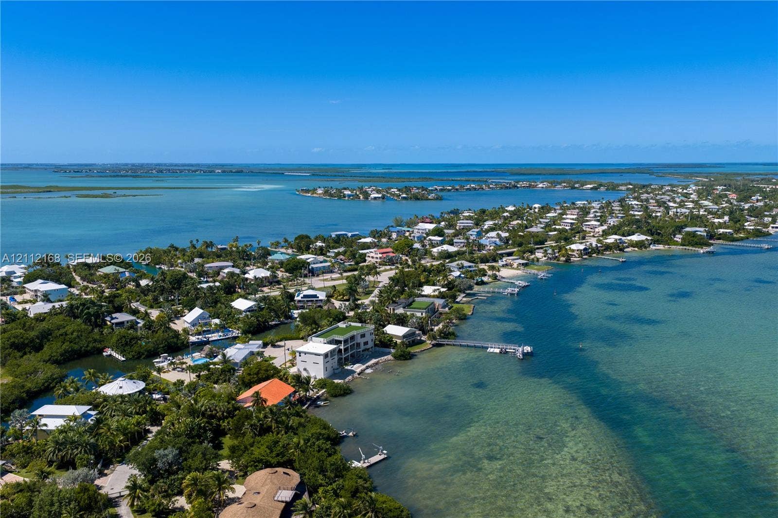 1041 E Buttonwood Drive, Sugarloaf Key, FL 33042 Aerial coastal perspective featuring direct water frontage, an expansive private dock, and surrounding tropical vegetation