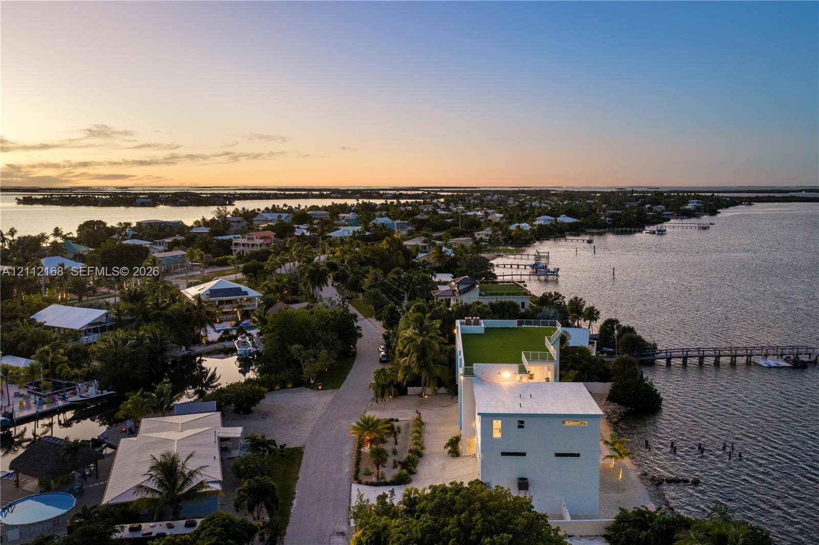 1041 E Buttonwood Drive, Sugarloaf Key, FL 33042 Waterfront property featuring a rooftop deck, private dock, multi-level exterior, and coastal location