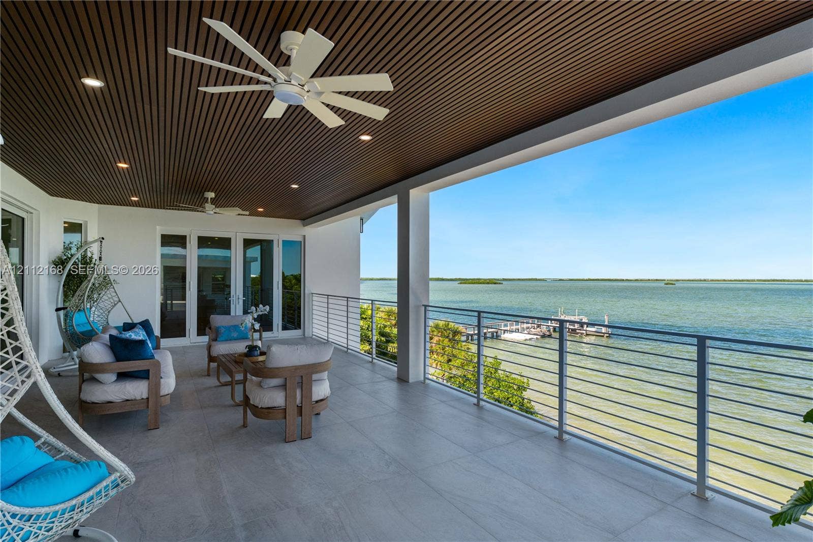 1041 E Buttonwood Drive, Sugarloaf Key, FL 33042 Covered terrace featuring a slatted wood-paneled ceiling, recessed lighting, ceiling fans, large-format tile flooring, and a metal railing system