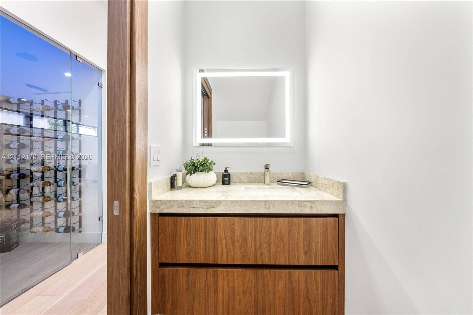 Vanity featuring a natural stone countertop, undermount sink, and wood-finish cabinetry