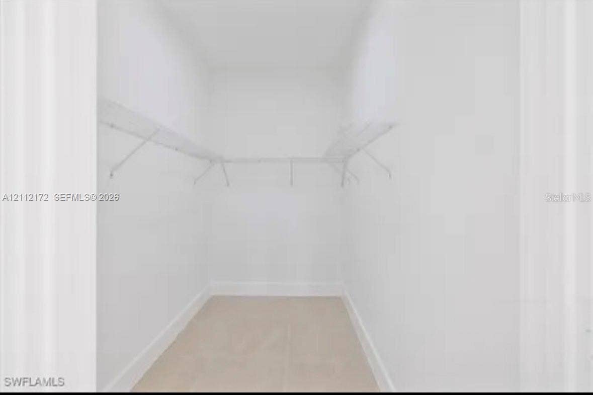Walk-in closet featuring neutral wall finishes, light-toned flooring, and wire shelving