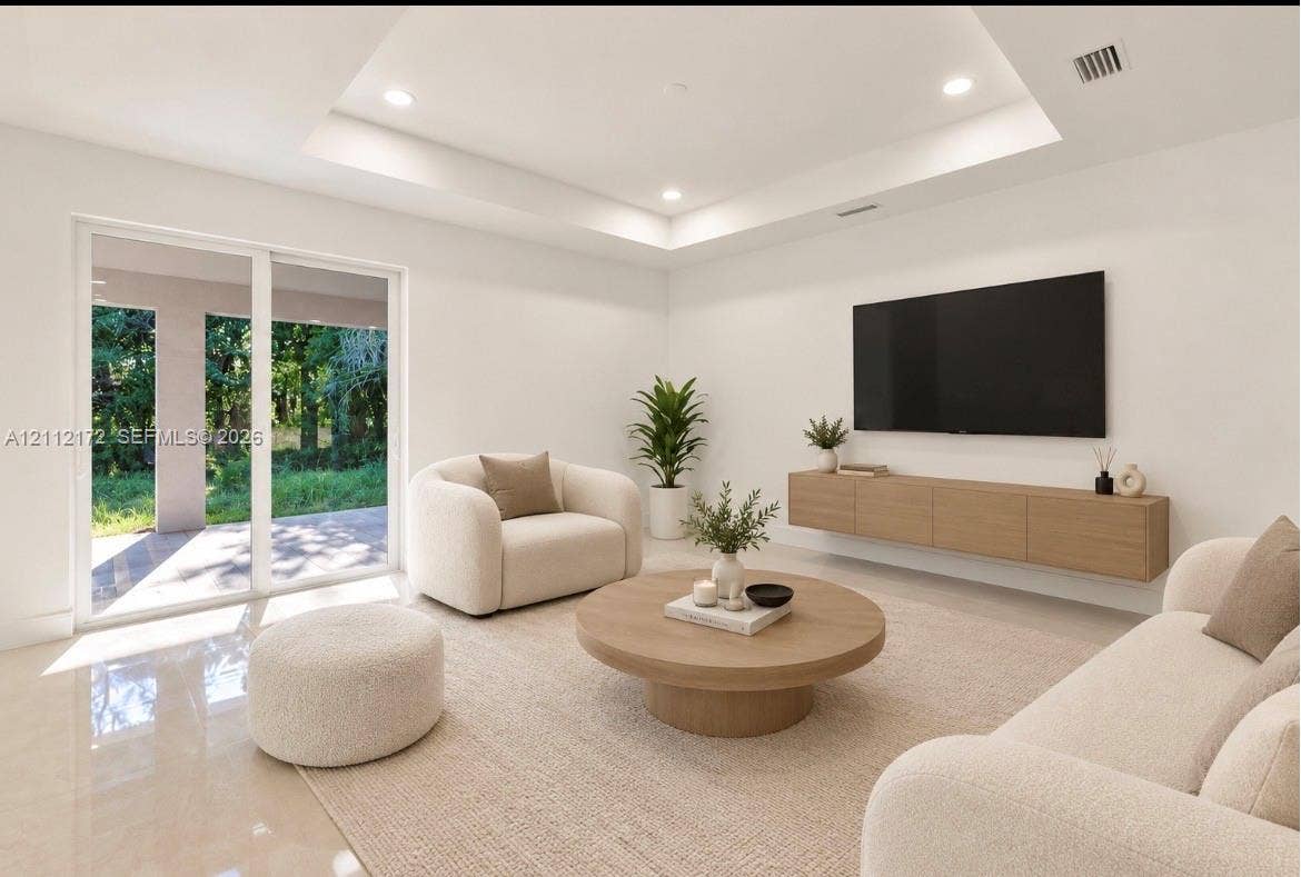 Tray ceiling with recessed lighting, large sliding glass doors, and wall-mounted cabinetry