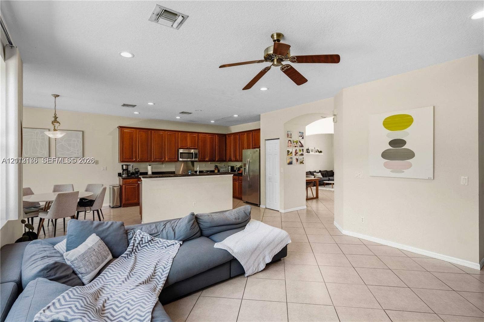 19143 Crystal Street, Weston, FL 33332 Open-concept kitchen featuring dark wood cabinetry, a breakfast bar, recessed lighting, a ceiling fan, and tile flooring