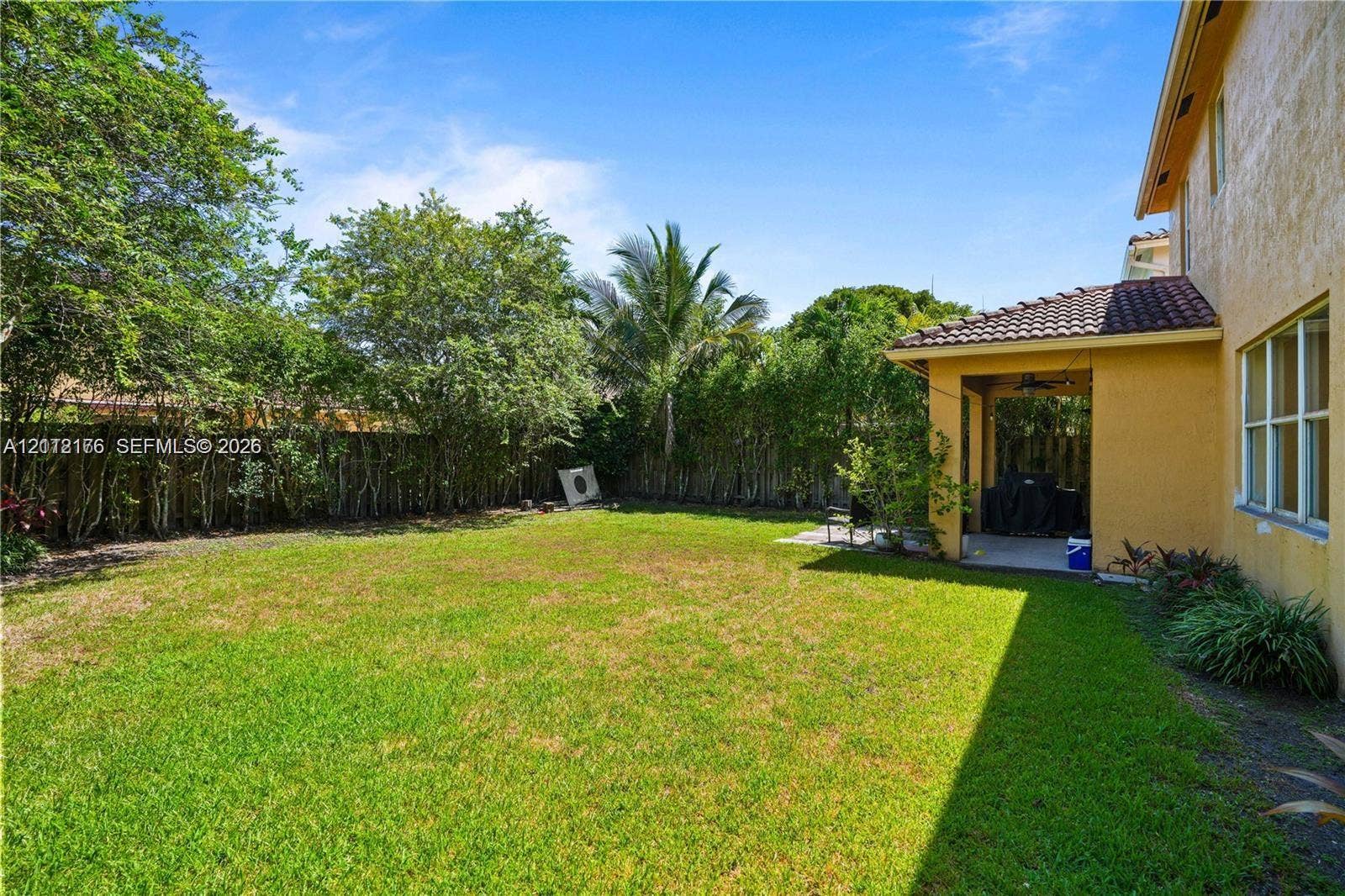 19143 Crystal Street, Weston, FL 33332 Backyard featuring a covered patio, tile roof, and perimeter greenery