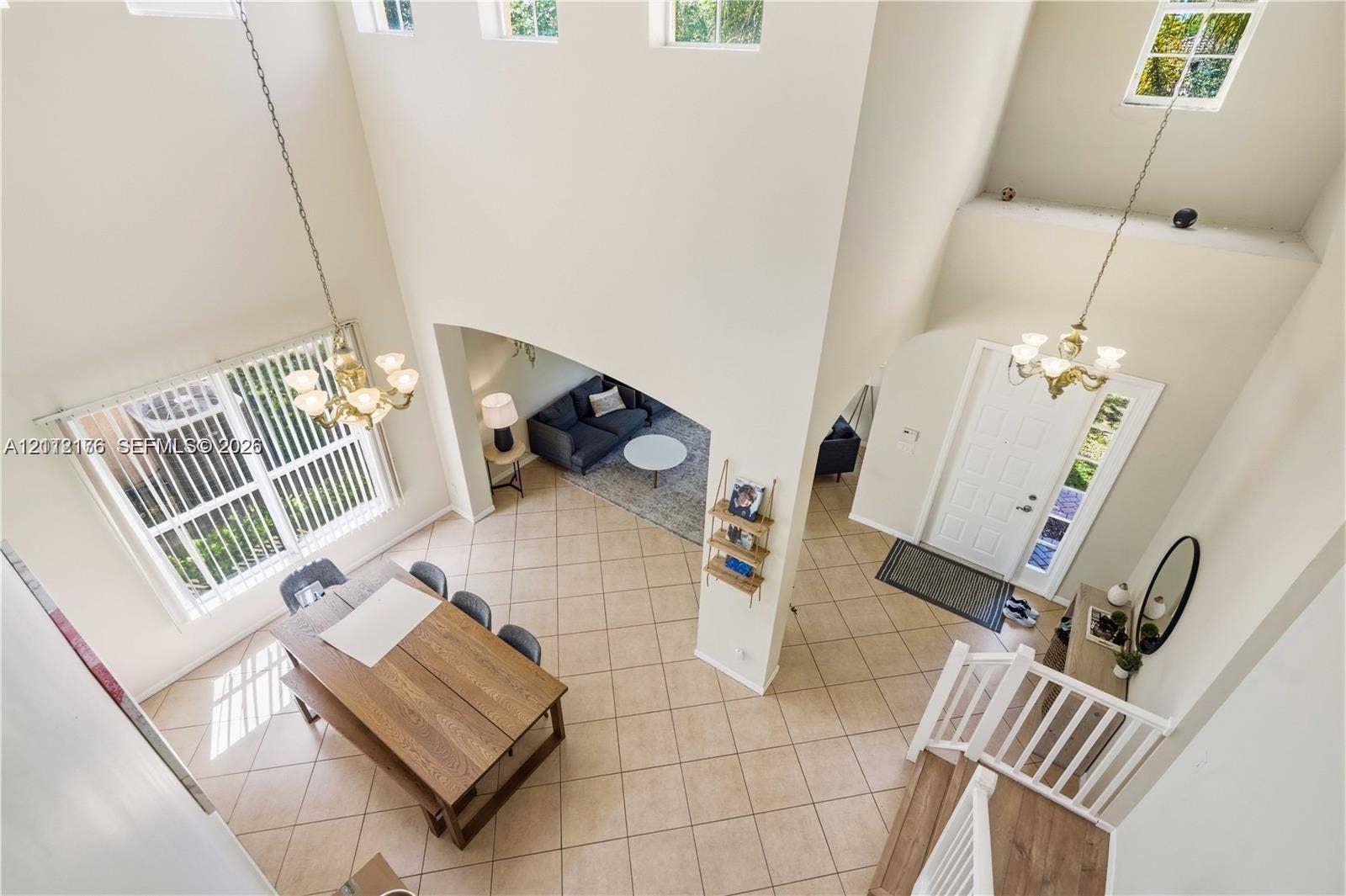 19143 Crystal Street, Weston, FL 33332 Double-height ceilings, ceramic tile flooring, arched wall openings, multi-tier windows, and traditional multi-arm chandeliers