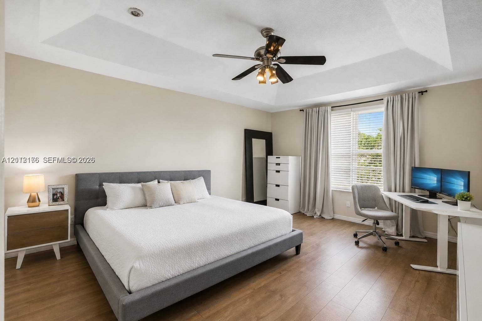 19143 Crystal Street, Weston, FL 33332 Tray ceiling featuring a central multi-light ceiling fan, wood-finish flooring, and natural light from a window with adjustable blinds