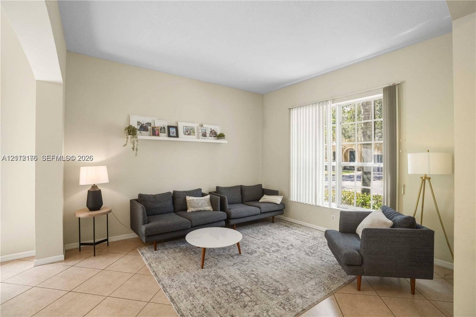 19143 Crystal Street, Weston, FL 33332 Living area featuring high ceilings, neutral wall tones, tile flooring, and a large multi-pane window with vertical blinds