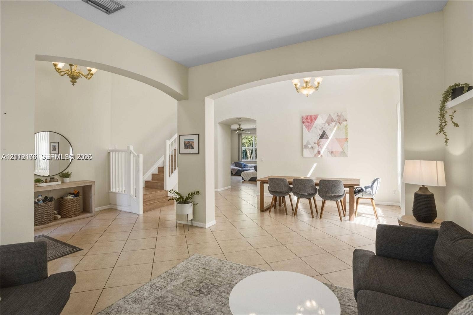 19143 Crystal Street, Weston, FL 33332 Open-concept interior featuring high ceilings, arched architectural detailing, ceramic tile flooring, built-in recessed shelving, and tiered light fixtures