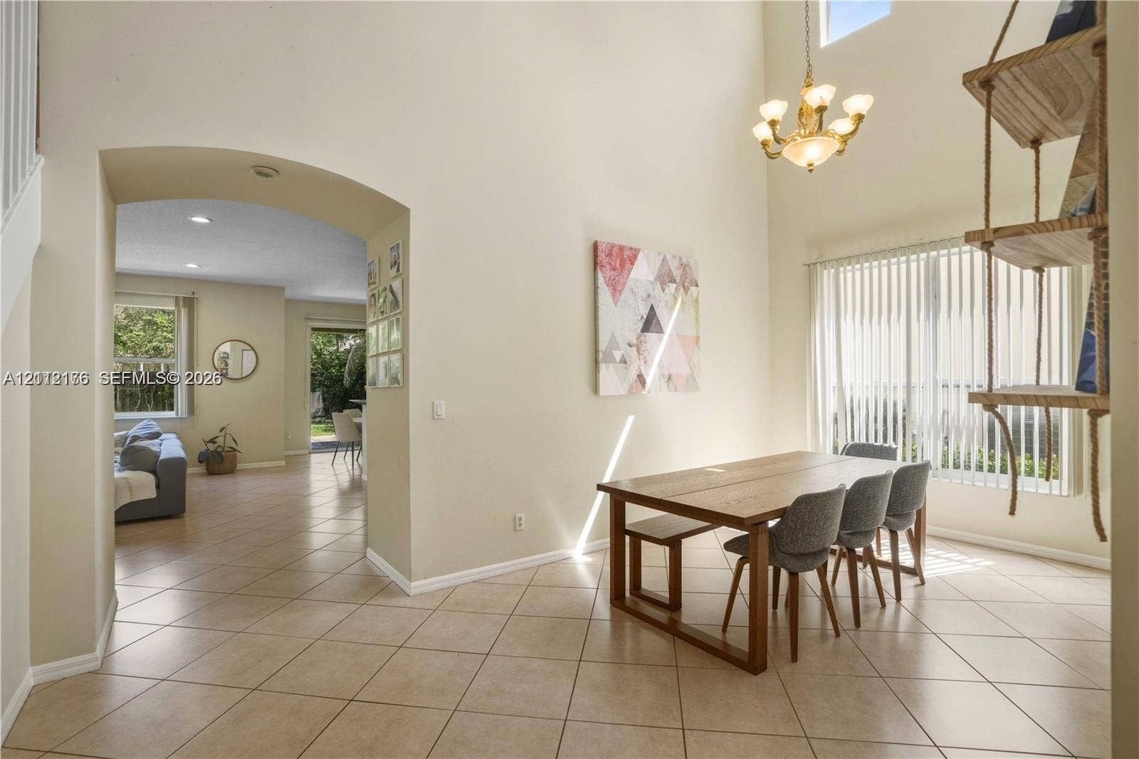 19143 Crystal Street, Weston, FL 33332 Two-story vaulted ceiling featuring a multi-arm chandelier and arched architectural opening with ceramic tile flooring