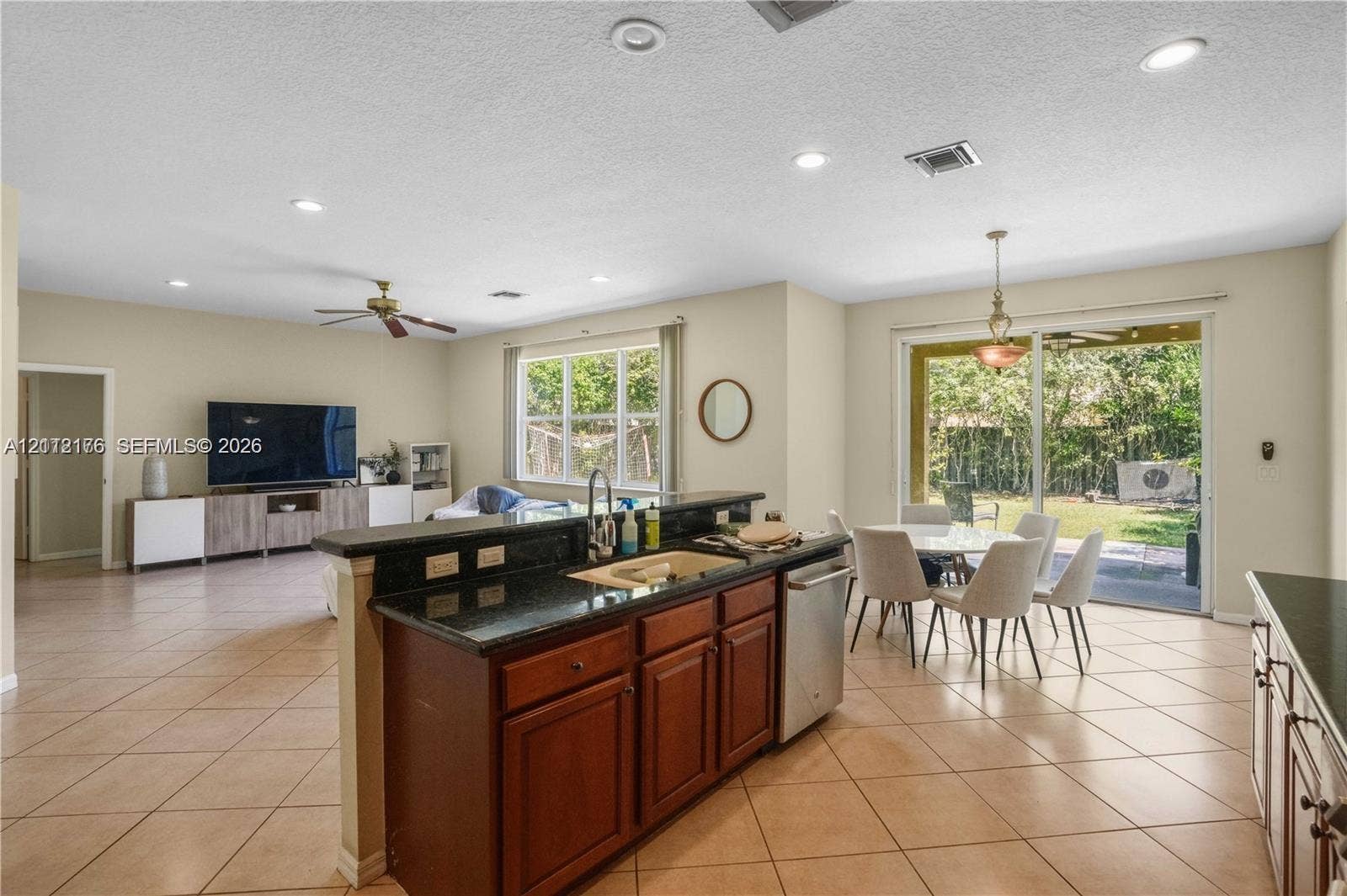 19143 Crystal Street, Weston, FL 33332 Kitchen featuring dark stone countertops, wood-finish cabinetry, stainless steel dishwasher, recessed lighting, and tile flooring