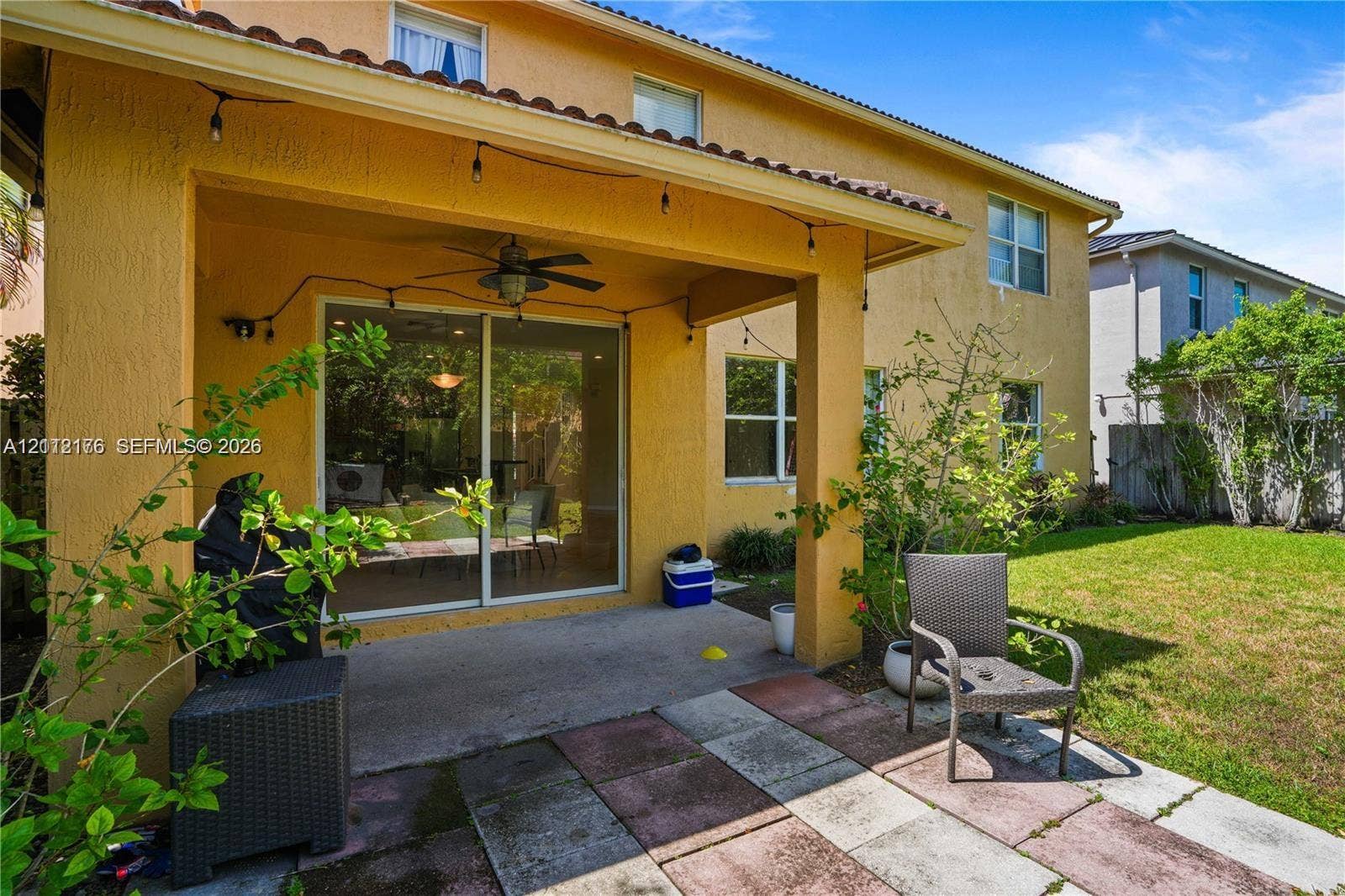 19143 Crystal Street, Weston, FL 33332 Covered patio with a concrete floor, ceiling fan, sliding glass door, and exterior paved hardscaping