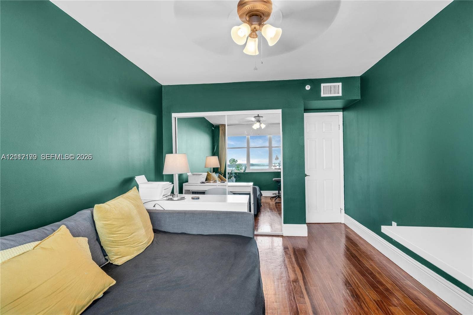 800 Claughton Island Drive, #1604, Miami, Miami, FL 33131 Wood-finish flooring, mirrored closet doors, and a ceiling-mounted light fixture with a fan