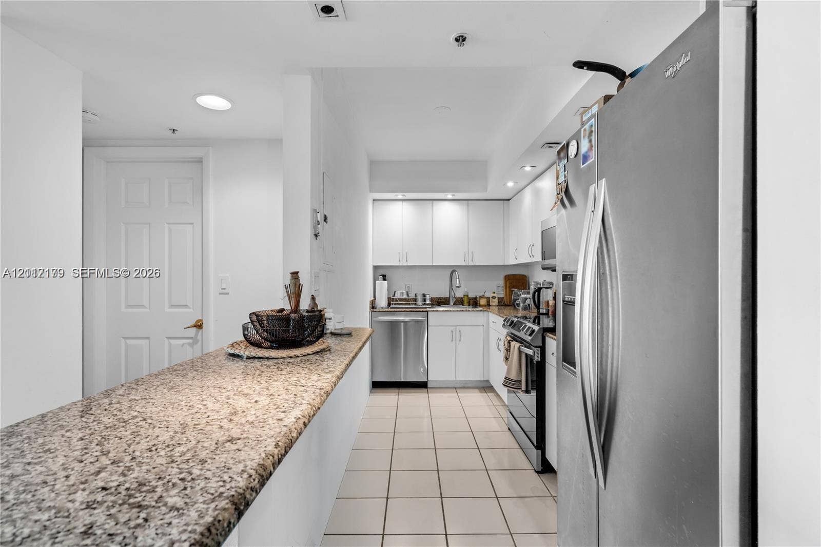 800 Claughton Island Drive, #1604, Miami, Miami, FL 33131 Kitchen featuring white cabinetry, stone-surface breakfast bar, ceramic tile flooring, stainless steel appliances, and recessed lighting
