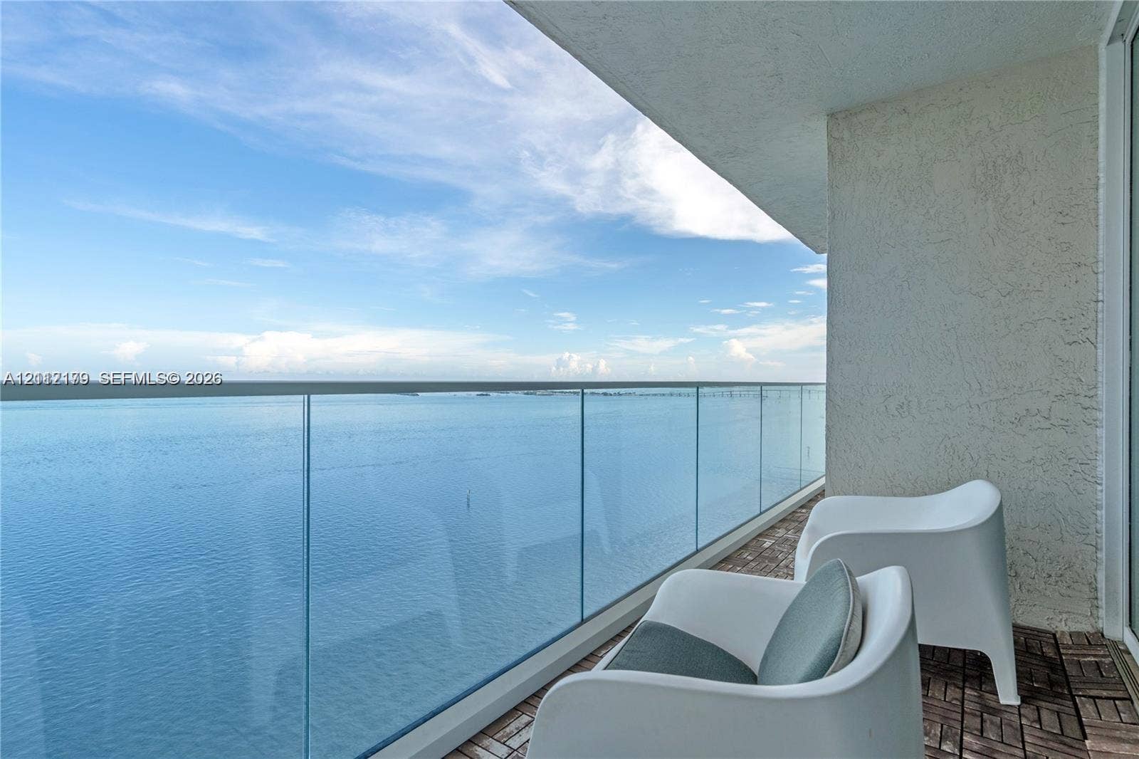 800 Claughton Island Drive, #1604, Miami, Miami, FL 33131 Private balcony featuring a glass panel railing, textured wall finish, and wood-finish modular tile flooring