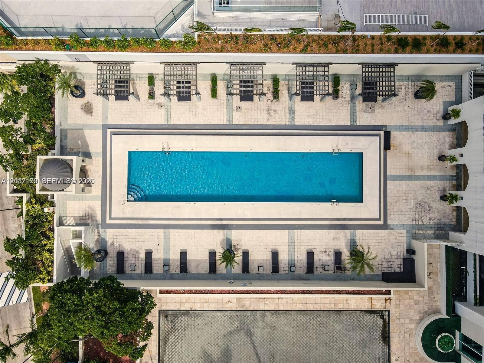 800 Claughton Island Drive, #1604, Miami, Miami, FL 33131 Rectangular lap pool featuring stone decking, multiple built-in pergola structures, integrated landscaping, and a tiered patio surround