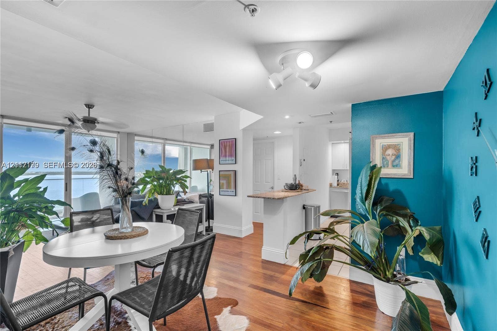 800 Claughton Island Drive, #1604, Miami, Miami, FL 33131 Interior space featuring wood-finish flooring, floor-to-ceiling sliding glass doors, a built-in peninsula with a stone-finish countertop, and multi-directional ceiling-mounted track lighting