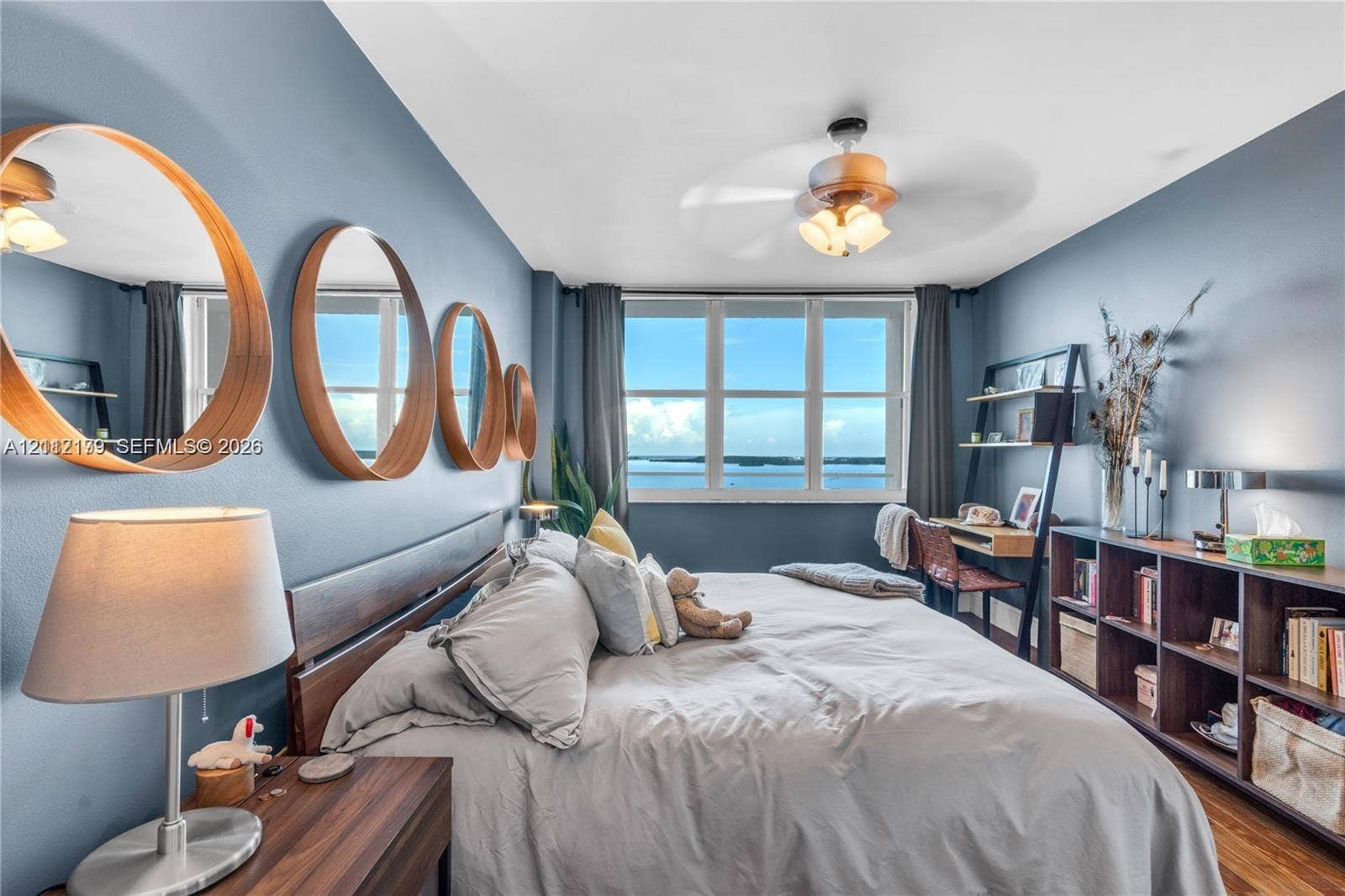 800 Claughton Island Drive, #1604, Miami, Miami, FL 33131 Multi-panel window with water backdrop, wood-finish flooring, and ceiling fan with integrated lighting