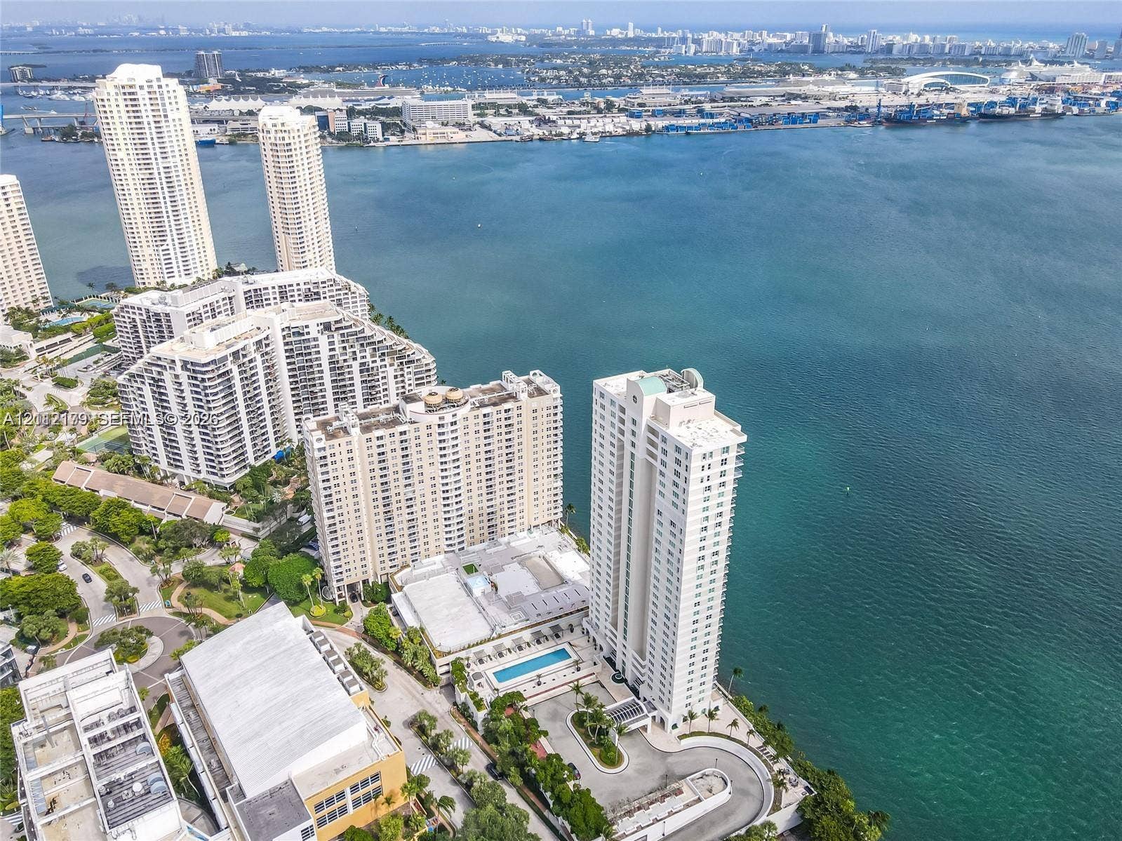 800 Claughton Island Drive, #1604, Miami, Miami, FL 33131 Aerial perspective of the high-rise structure featuring an outdoor swimming pool, paved motor court, mature landscaping, and waterfront positioning