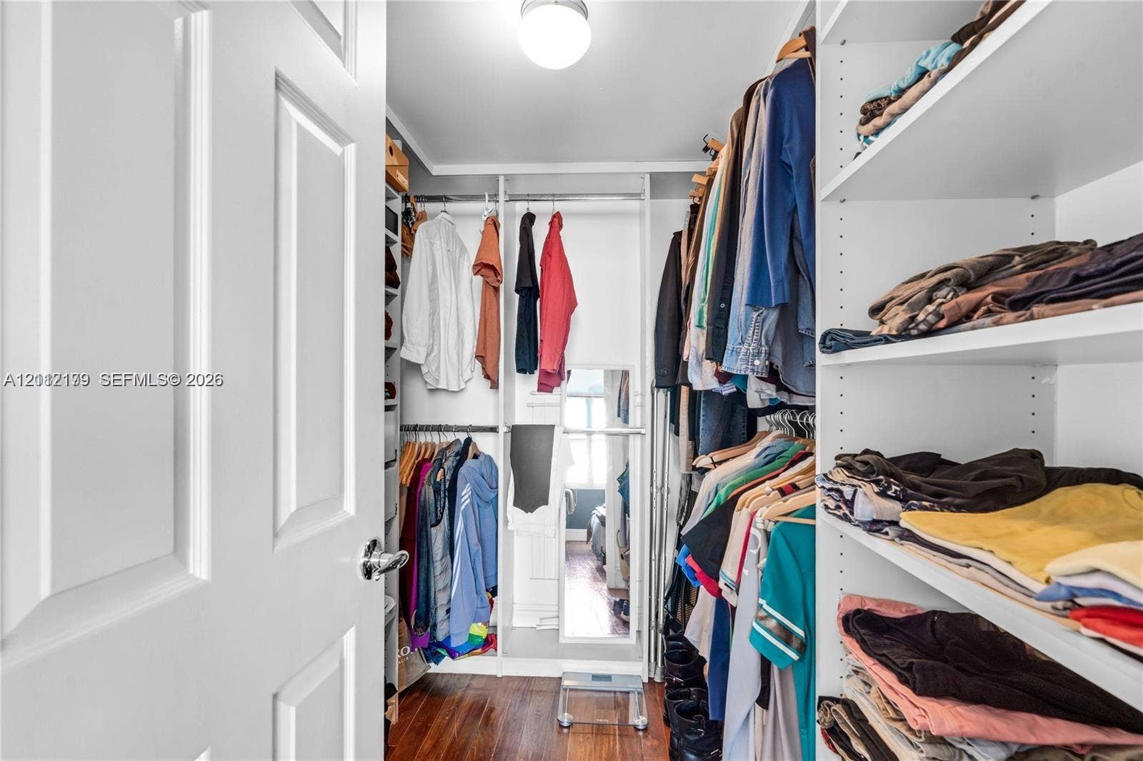 800 Claughton Island Drive, #1604, Miami, Miami, FL 33131 Walk-in closet featuring white built-in shelving, adjustable storage units, integrated hanging rods, and wood-finish flooring