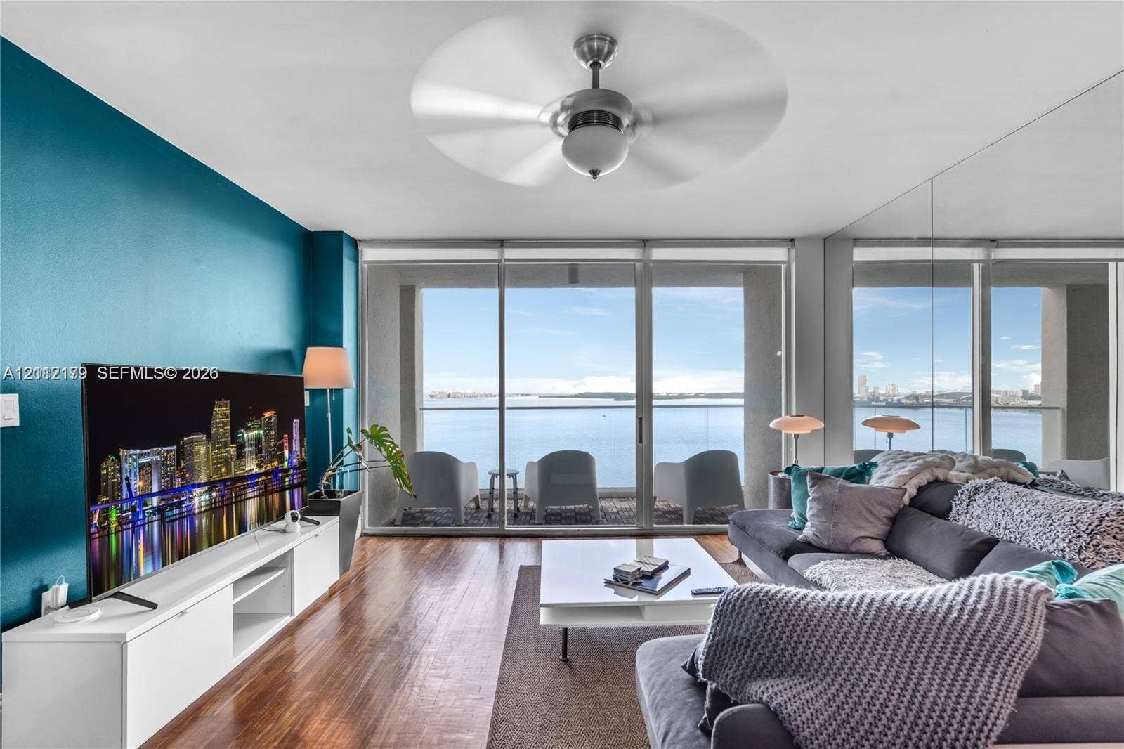 800 Claughton Island Drive, #1604, Miami, Miami, FL 33131 Floor-to-ceiling sliding glass doors, full-wall mirror, wood-finish flooring, ceiling fan, and direct water horizon