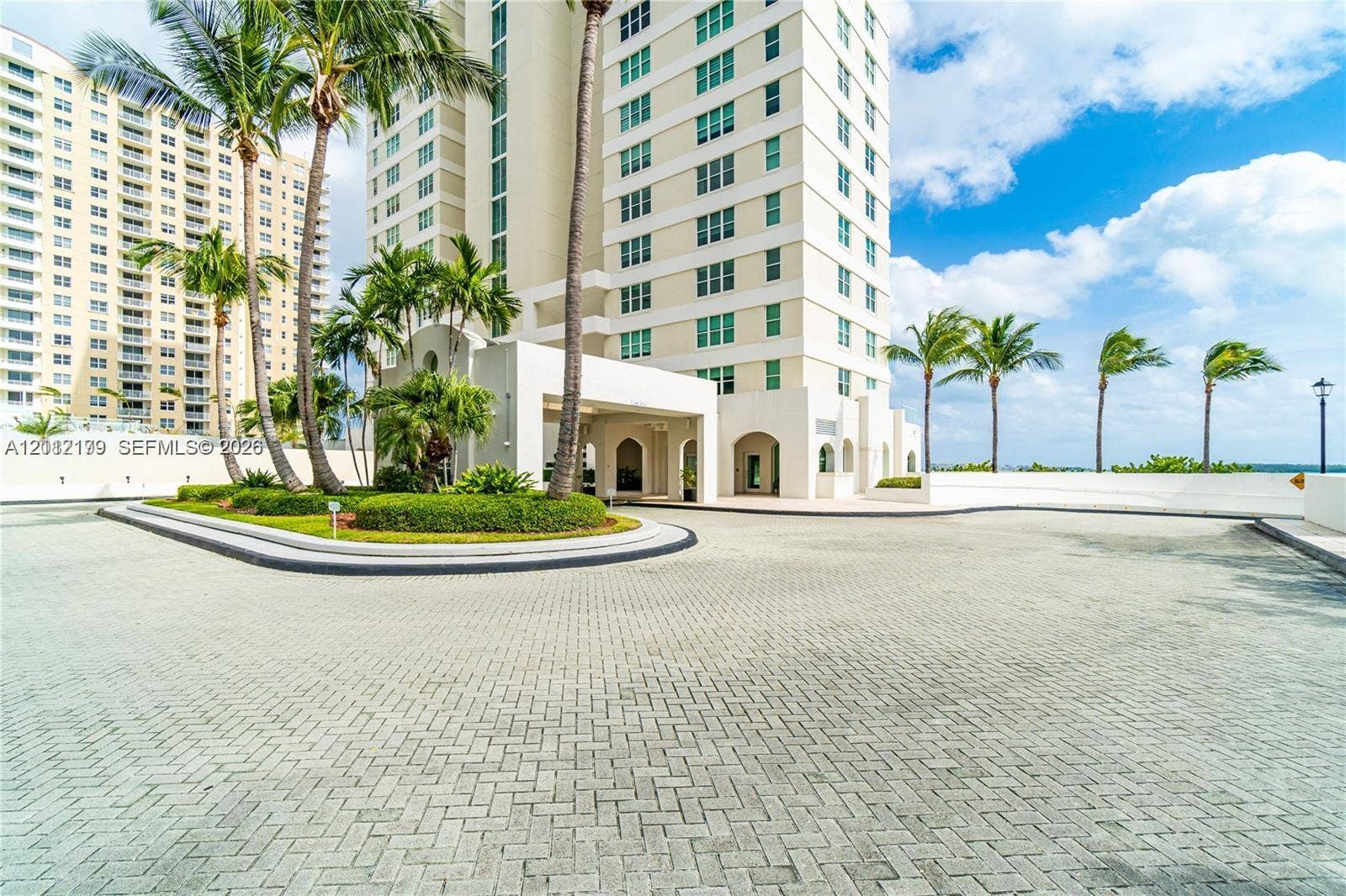 800 Claughton Island Drive, #1604, Miami, Miami, FL 33131 High-rise exterior featuring a paved arrival courtyard, porte-cochre, mature palm trees, and manicured landscaping