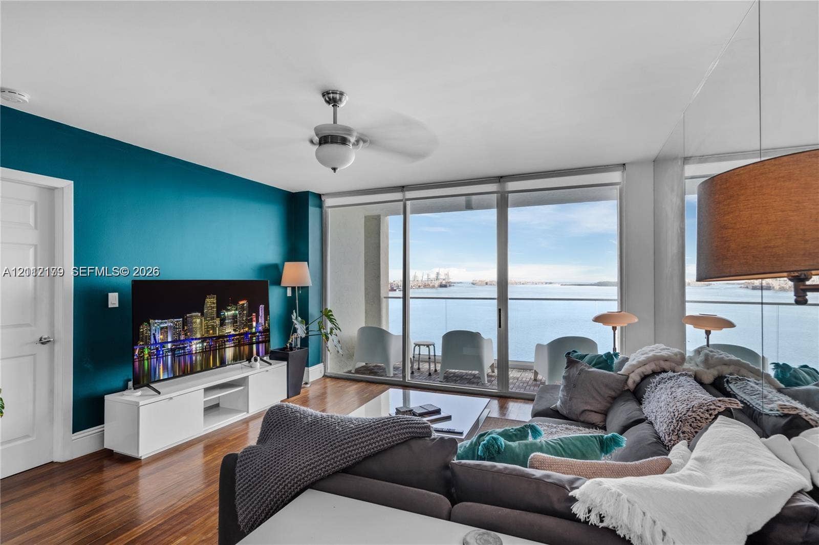 800 Claughton Island Drive, #1604, Miami, Miami, FL 33131 Living space featuring floor-to-ceiling glass sliding doors, wood-finish flooring, a ceiling fan with integrated light fixture, and a mirrored wall panel