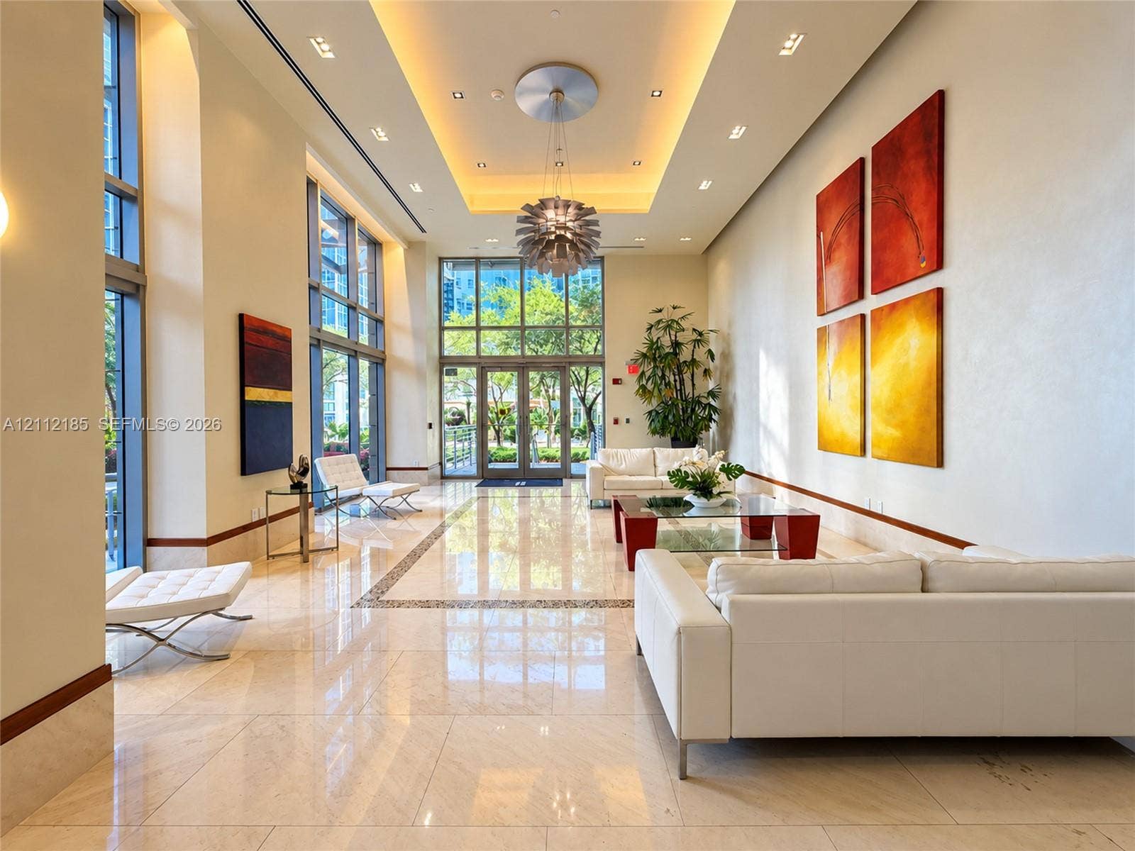 1060 Brickell Avenue, #2401, Miami, FL 33131 Expansive lobby featuring polished stone flooring, floor-to-ceiling windows, recessed cove lighting, and a modern sculptural chandelier