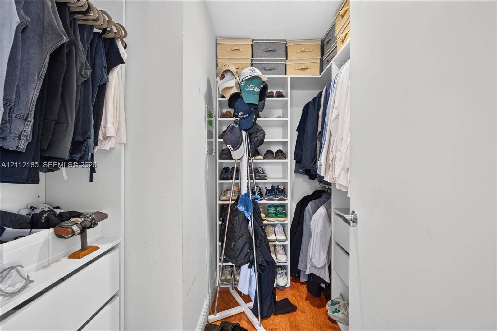 1060 Brickell Avenue, #2401, Miami, FL 33131 Walk-in closet featuring white built-in shelving, vertical storage compartments, and drawers with polished metal hardware