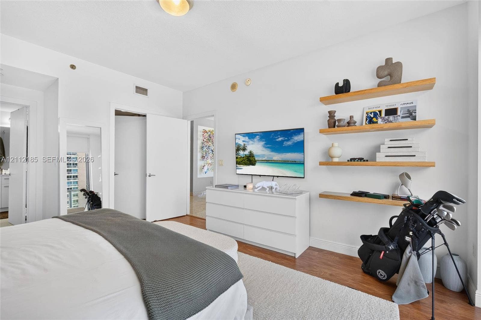 1060 Brickell Avenue, #2401, Miami, FL 33131 Wood-finish flooring, four floating natural wood shelves, and interior doors with brushed nickel hardware